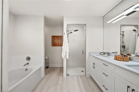 a bathroom with a tub sink and mirror