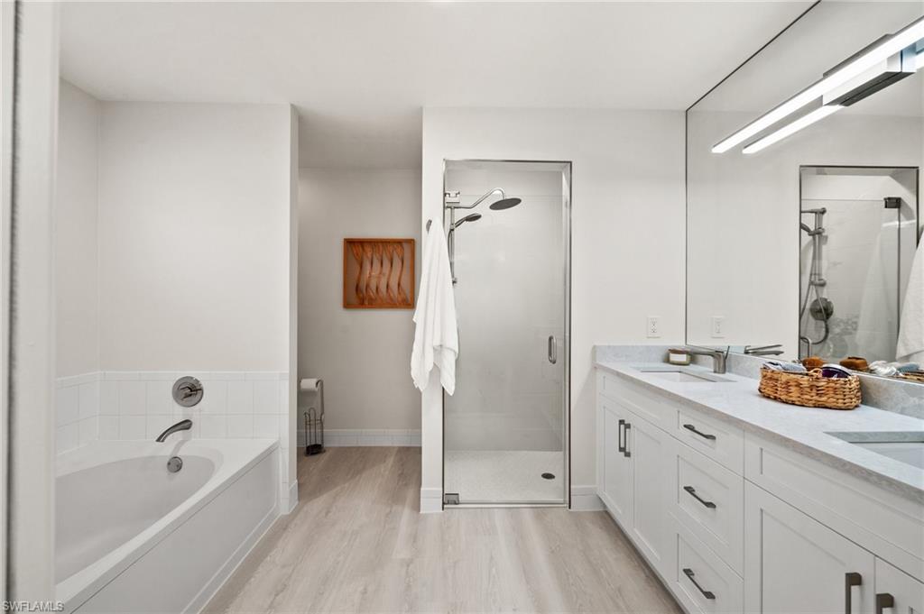 1590 Weybridge Circle, Unit 52 Naples, FL 34110 - Photo 19 of 36 a bathroom with a tub sink and mirror