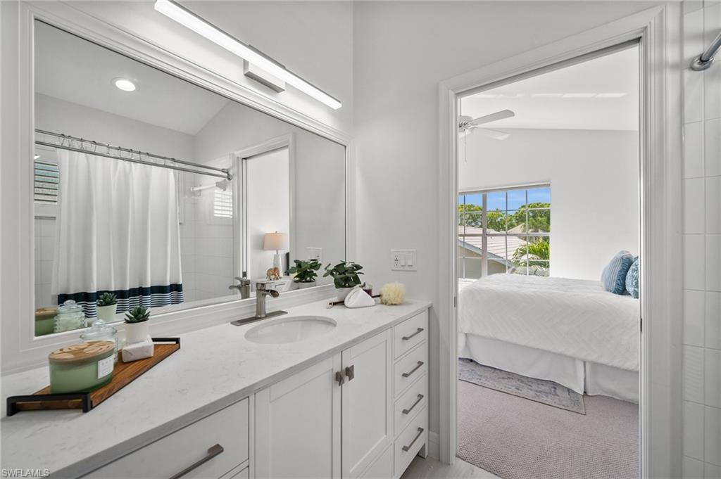 1590 Weybridge Circle, Unit 52 Naples, FL 34110 - Photo 23 of 36 a bathroom with a sink a mirror and a window