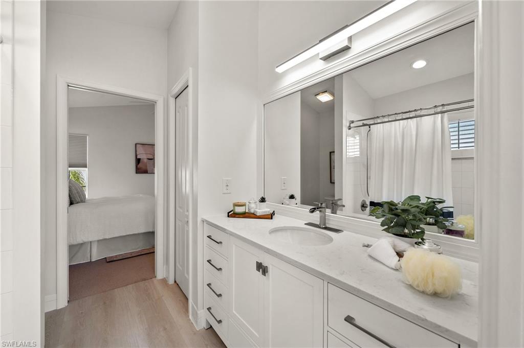 1590 Weybridge Circle, Unit 52 Naples, FL 34110 - Photo 24 of 36 a bathroom with a double vanity sink and mirror