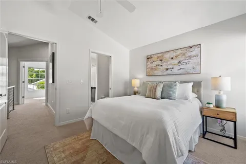a bedroom with a large bed and paintings on the wall