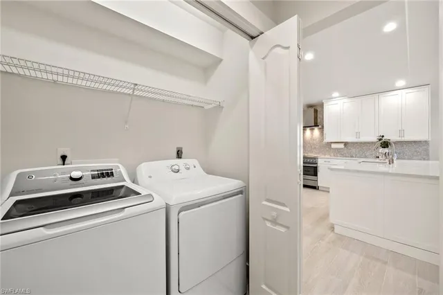 a view of washer and dryer with bathroom in the background