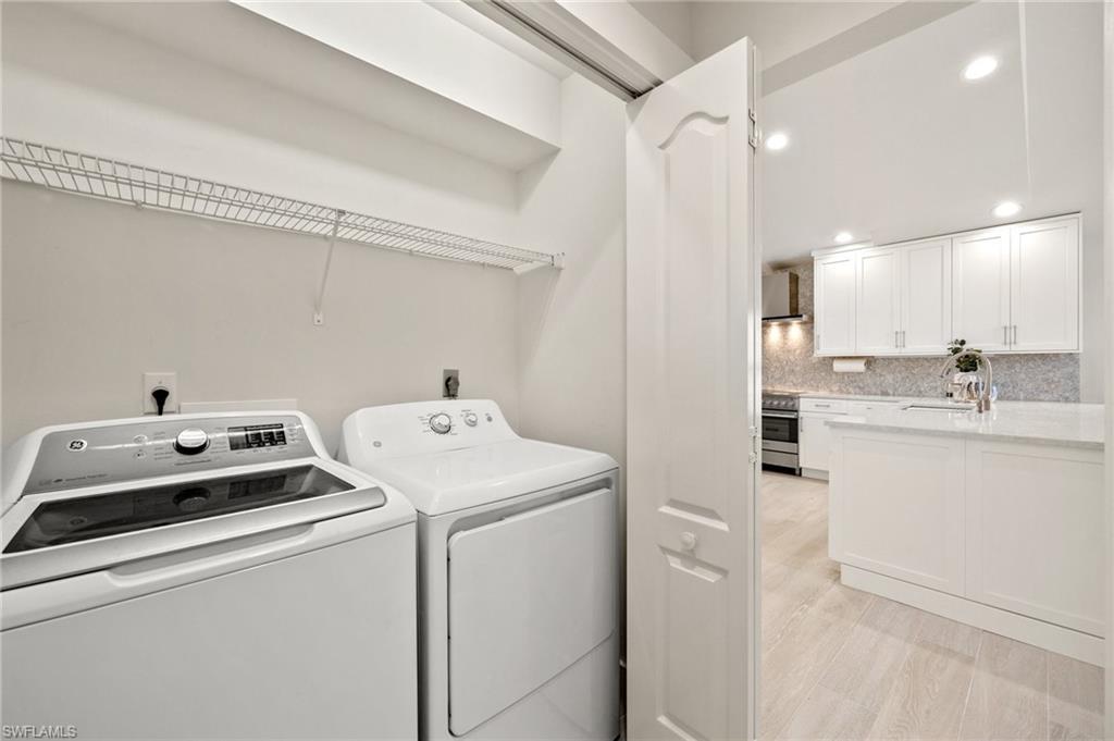 1590 Weybridge Circle, Unit 52 Naples, FL 34110 - Photo 29 of 36 a view of washer and dryer with bathroom in the background
