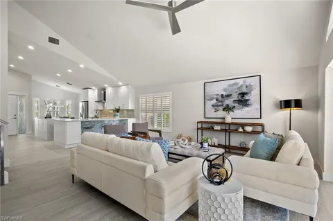 a living room with furniture and a view of kitchen