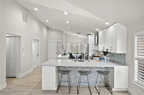 a kitchen with center island white cabinets and stainless steel appliances