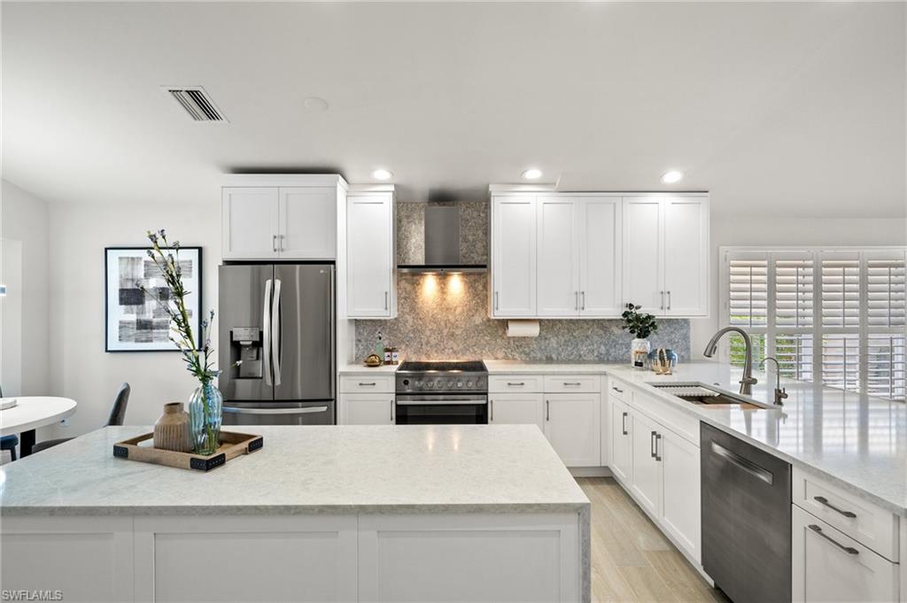 1590 Weybridge Circle, Unit 52 Naples, FL 34110 - Photo 9 of 36 a kitchen with a refrigerator and a sink