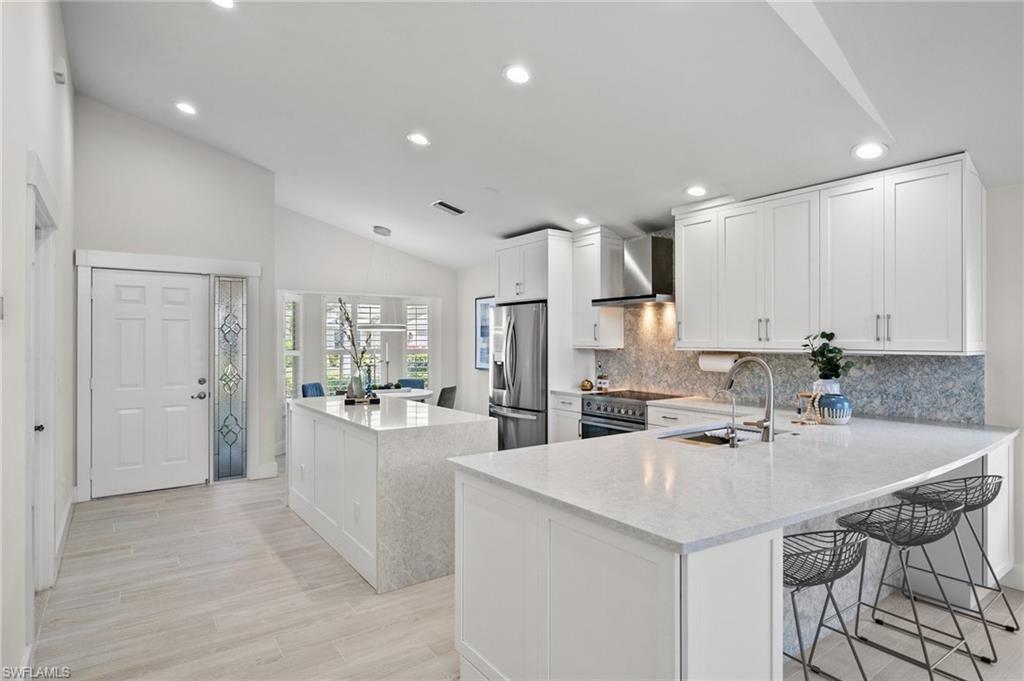 1590 Weybridge Circle, Unit 52 Naples, FL 34110 - Photo 10 of 36 a kitchen with stainless steel appliances kitchen island granite countertop a sink and cabinets