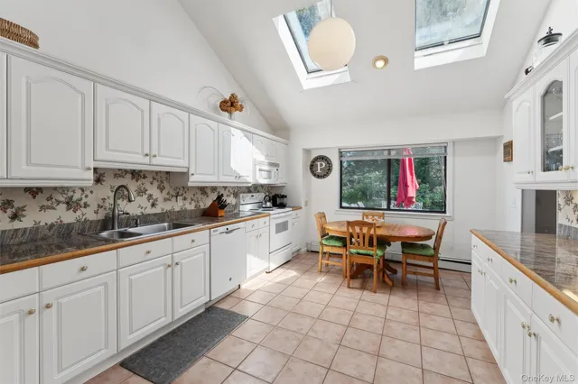a kitchen with a sink dining table and chairs