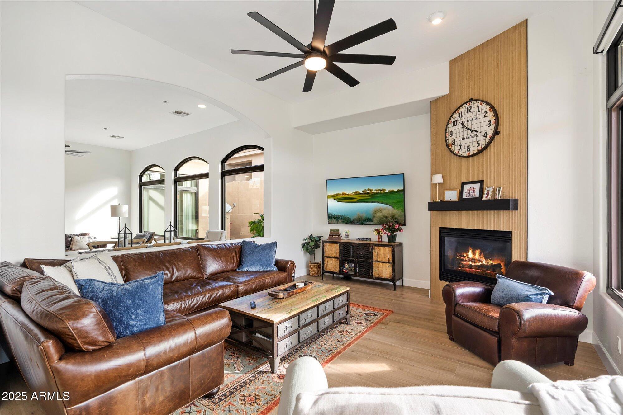 10747 East Greenway Road Scottsdale, AZ 85255 - Photo 11 of 56 a living room with furniture a clock and a fireplace