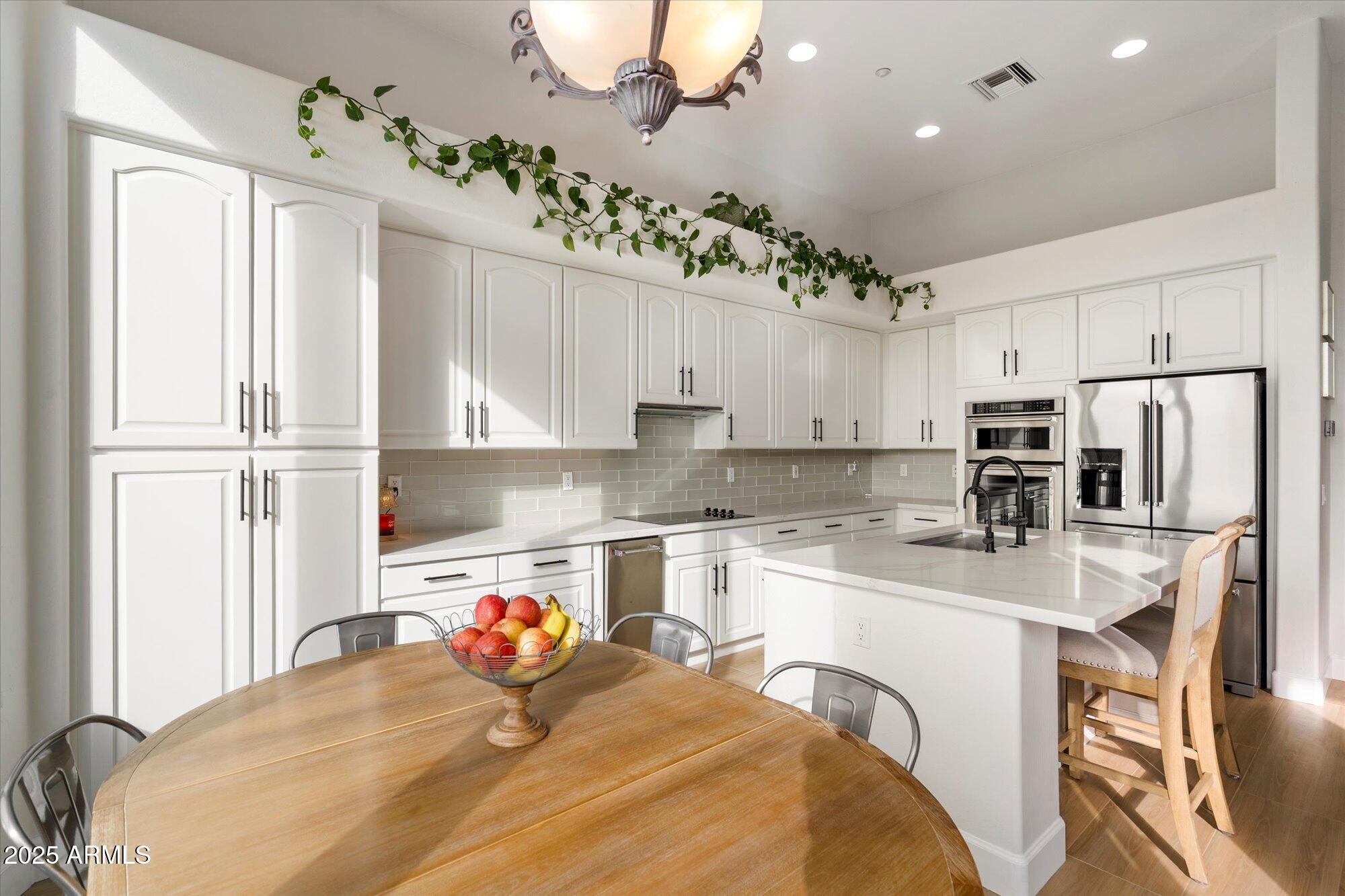 10747 East Greenway Road Scottsdale, AZ 85255 - Photo 15 of 56 a kitchen with kitchen island a sink appliances and cabinets
