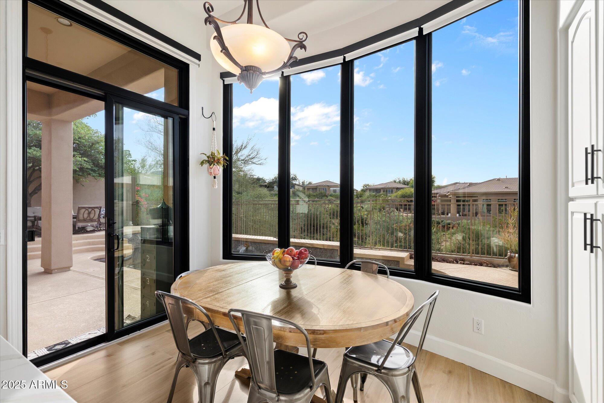 10747 East Greenway Road Scottsdale, AZ 85255 - Photo 2 of 56 a view of a dining room with furniture large windows and wooden floor