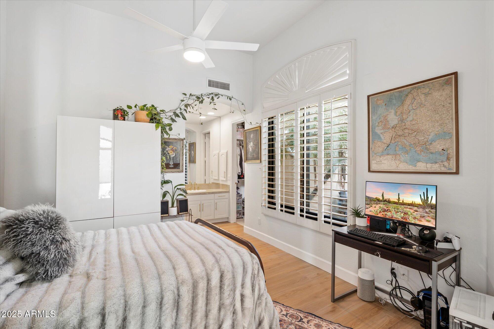 10747 East Greenway Road Scottsdale, AZ 85255 - Photo 22 of 56 a bedroom with a bed a computer on the desk and a large mirror next to a window