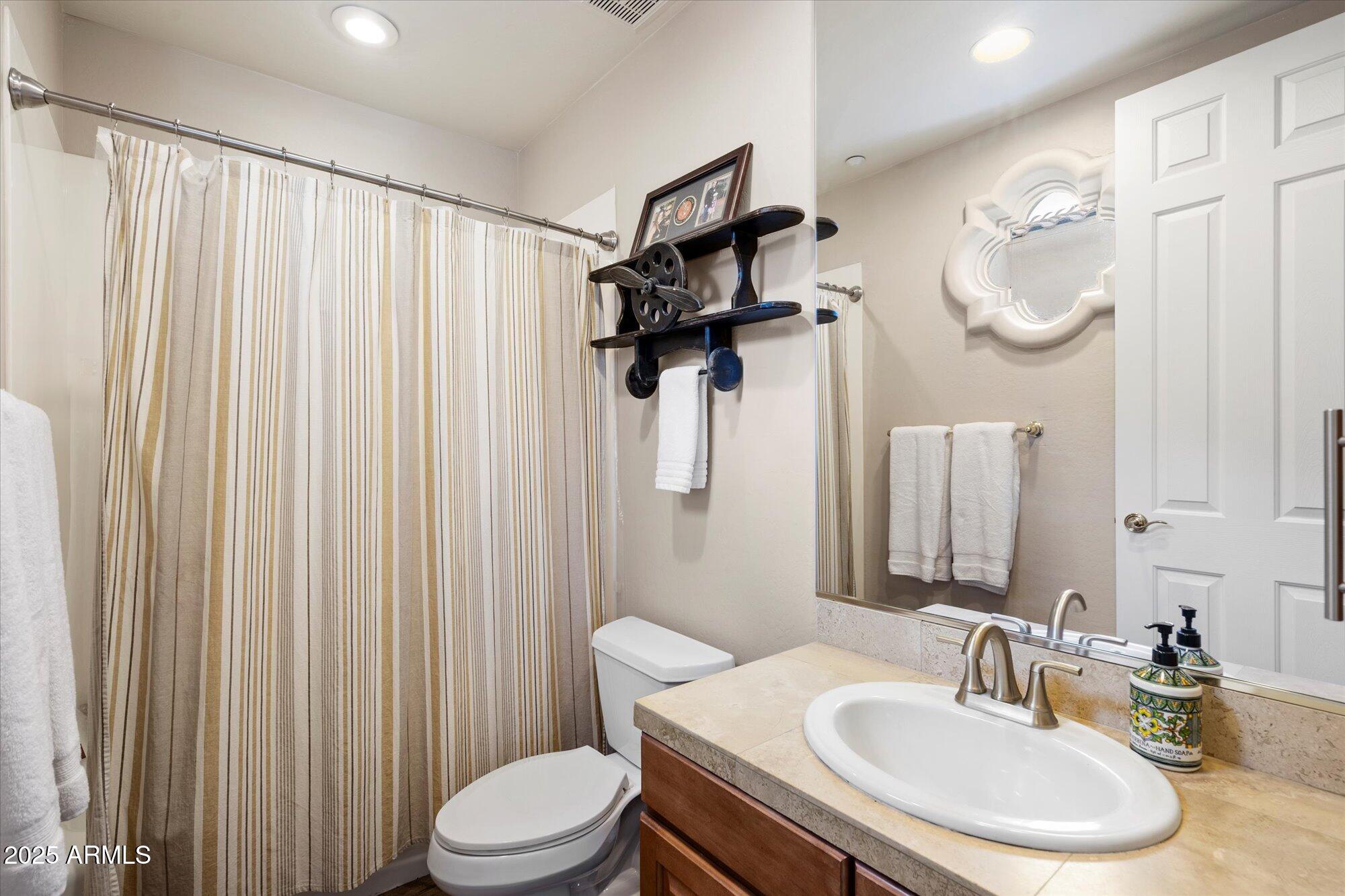 10747 East Greenway Road Scottsdale, AZ 85255 - Photo 29 of 56 a bathroom with a sink a toilet and shower curtain