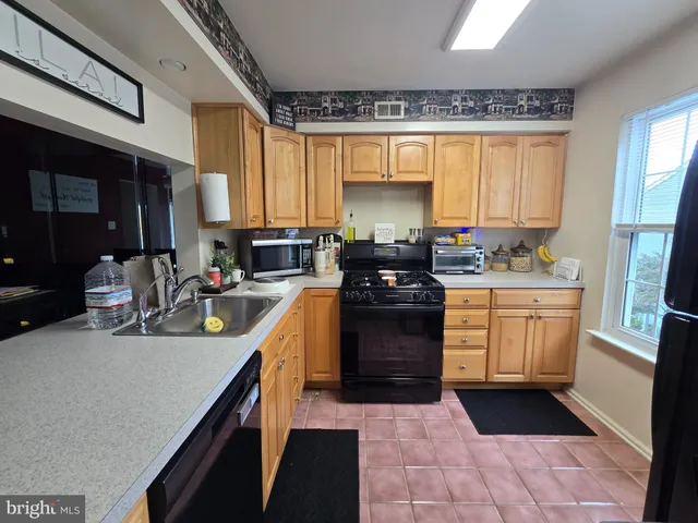a kitchen with a sink a stove cabinets and a window
