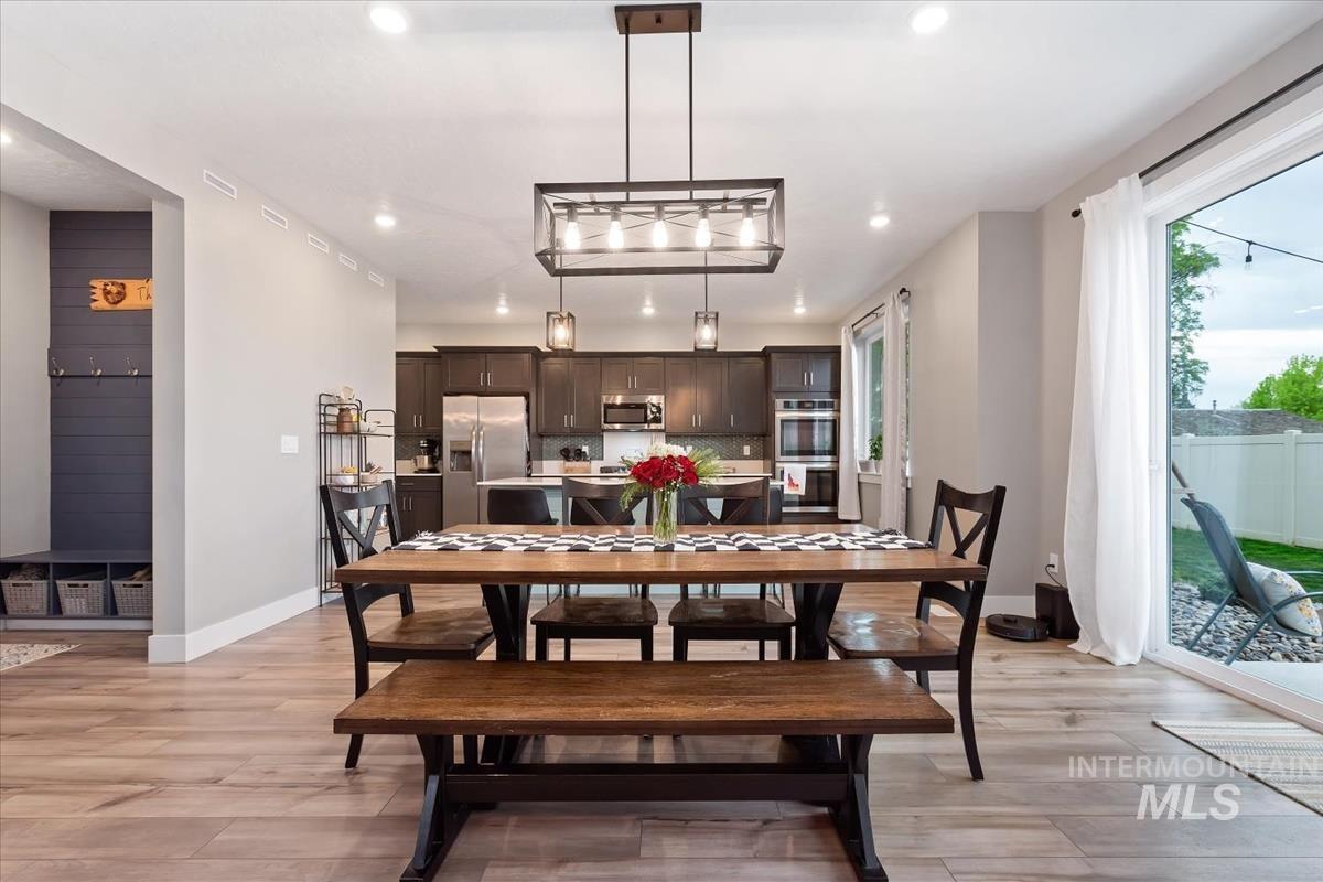 815 Knowledge Street Middleton, ID 83644 - Photo 19 of 49 Open-concept dining area with wood-finish flooring, recessed lighting, and a linear chandelier