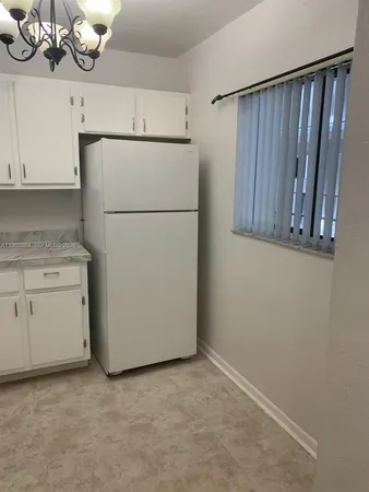 a view of a kitchen with cabinets and washer dryer