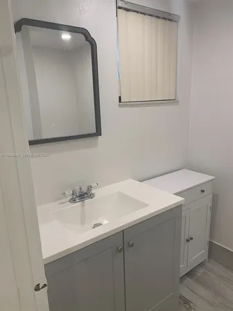 a bathroom with a sink vanity and mirror