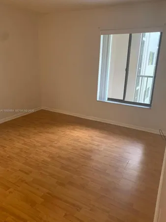 a view of an empty room with chandelier fan