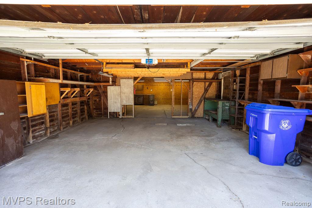 33033 Edgegrove Road Fraser, MI 48026 - Photo 19 of 20 Spacious garage featuring a concrete floor, exposed wood framing, built-in shelving, and overhead lighting