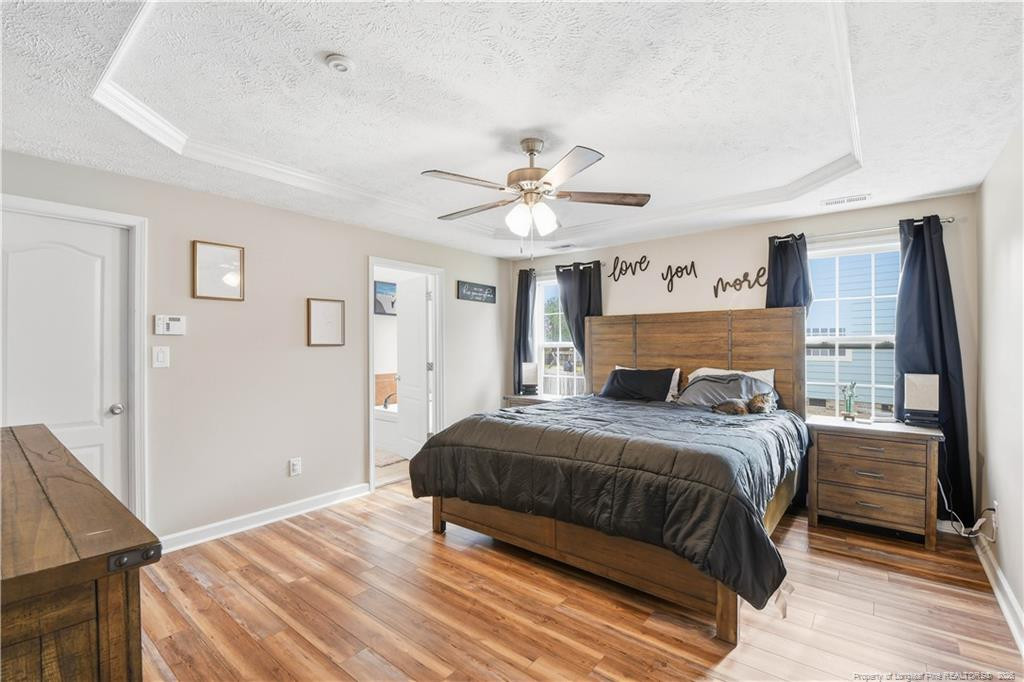 212 Lennox Loop Raeford, NC 28376 - Photo 25 of 47 a bedroom with a large bed and a chandelier