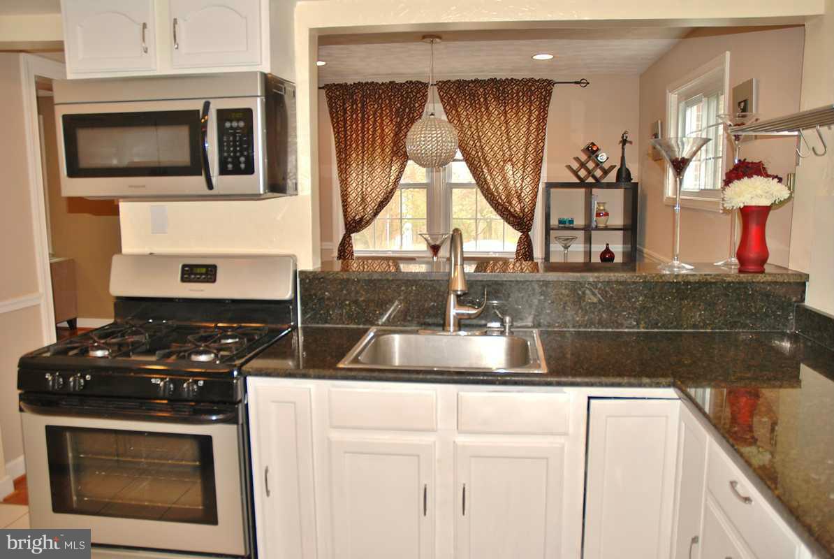11709 Lytle Street Silver Spring, MD 20902 - Photo 14 of 24 a kitchen with a stove and a microwave