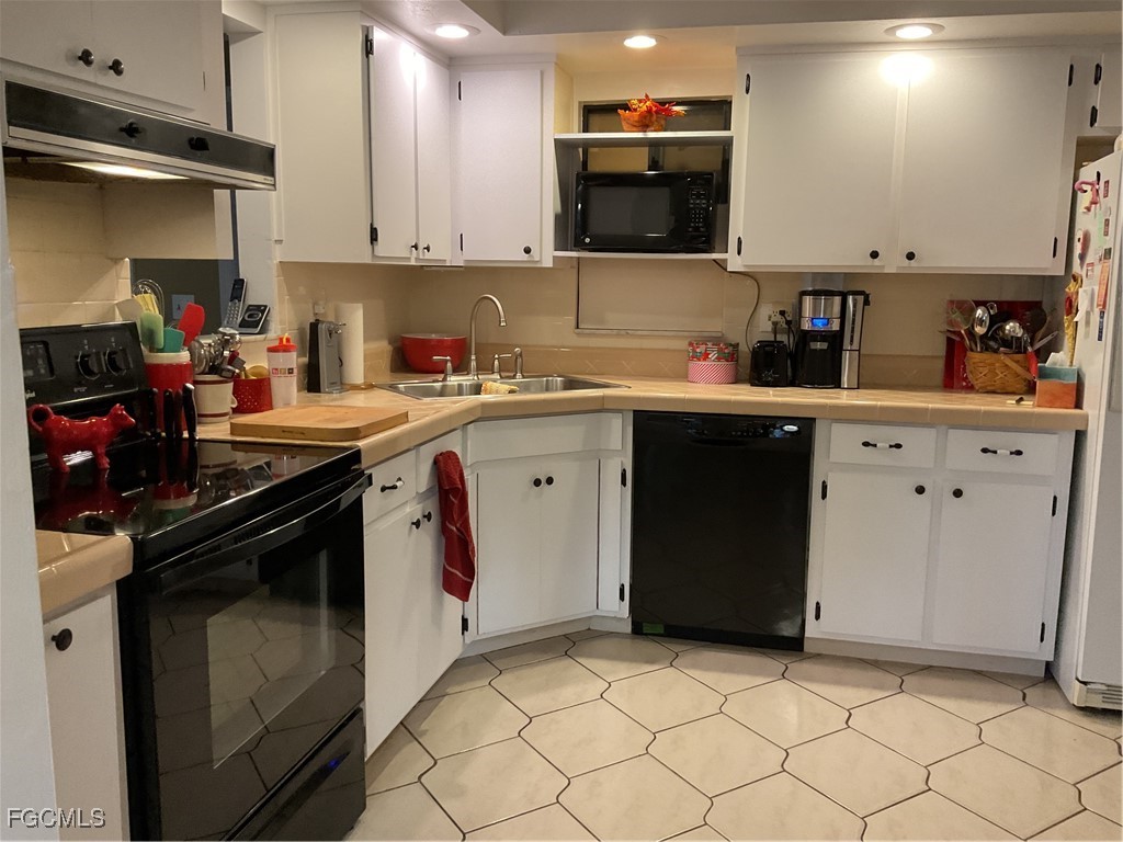 1002 Michael Avenue Lehigh Acres, FL 33936 - Photo 12 of 34 a kitchen with a sink and cabinets