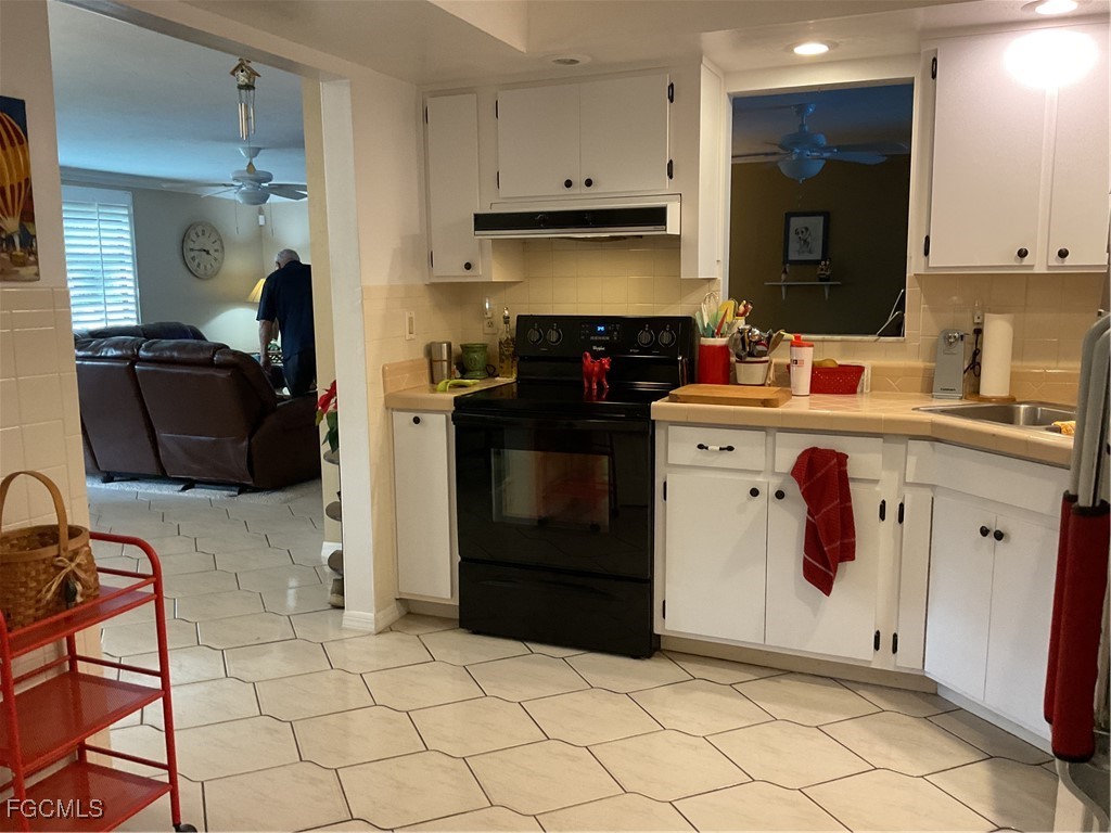 1002 Michael Avenue Lehigh Acres, FL 33936 - Photo 17 of 34 a kitchen with a cabinets and a stove top oven