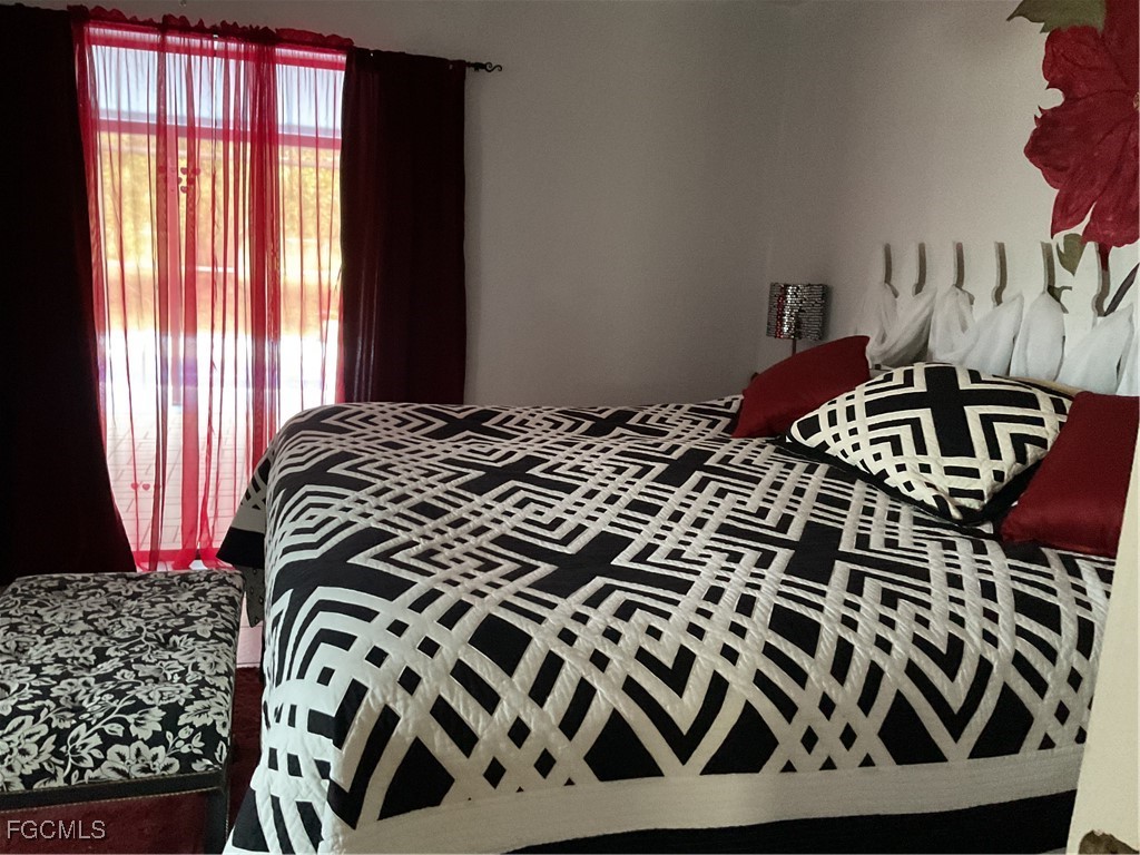 1002 Michael Avenue Lehigh Acres, FL 33936 - Photo 27 of 34 a bedroom with a bed and a window