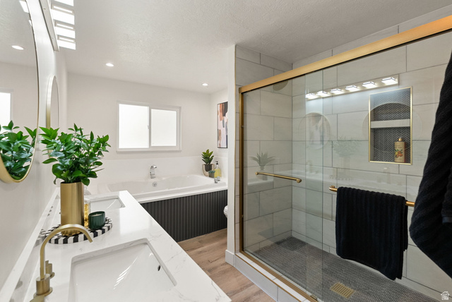 368 Spring Creek Road Providence, UT 84332 - Photo 10 of 45 Full bath featuring double vanity, light wood-type flooring, a stall shower, a textured ceiling, and a garden tub