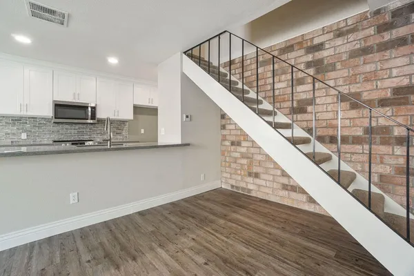 a view of kitchen with microwave and wooden floor