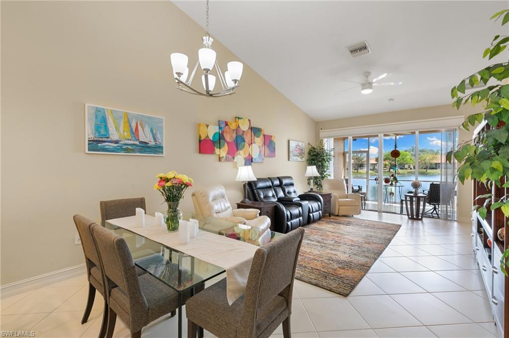8140 Chancel Court, Unit 2 Naples, FL 34104 - Photo 11 of 39 Dining area featuring a ceiling fan, vaulted ceiling, a water view, light tile patterned floors, and suspended lighting