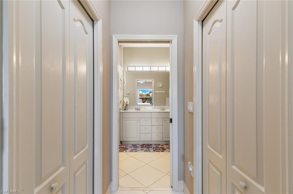 8140 Chancel Court, Unit 2 Naples, FL 34104 - Photo 14 of 39 Bathroom with double vanity, light tile patterned floors, and a closet