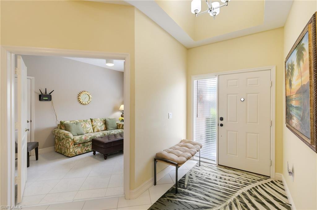 8140 Chancel Court, Unit 2 Naples, FL 34104 - Photo 19 of 39 Foyer entrance with light tile patterned floors and a chandelier