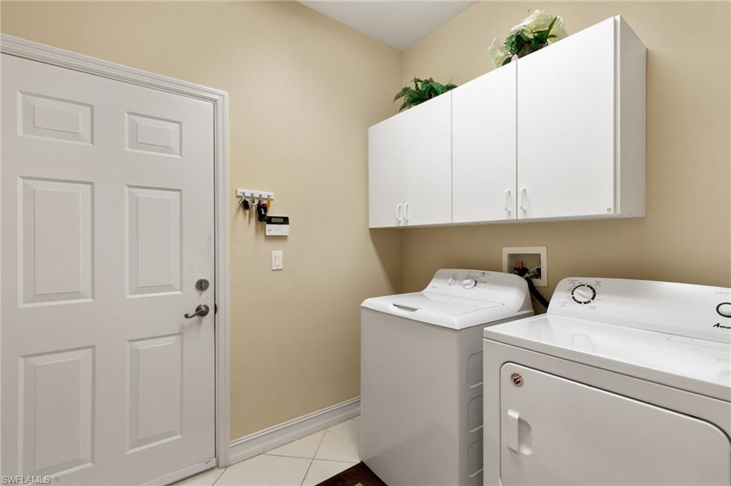 8140 Chancel Court, Unit 2 Naples, FL 34104 - Photo 21 of 39 Laundry room featuring cabinet space, light tile patterned floors, and separate washer and dryer