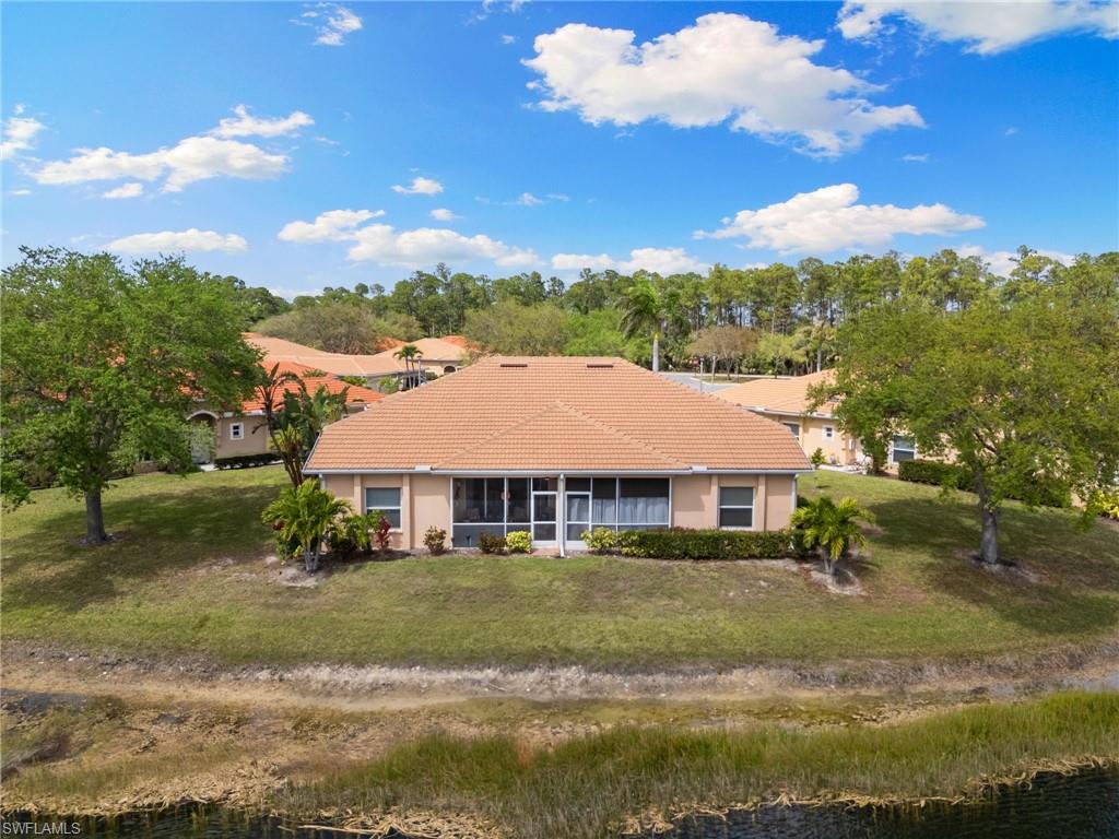 8140 Chancel Court, Unit 2 Naples, FL 34104 - Photo 34 of 39 View of front of property with a tile roof, a front lawn, a water view, and a sunroom