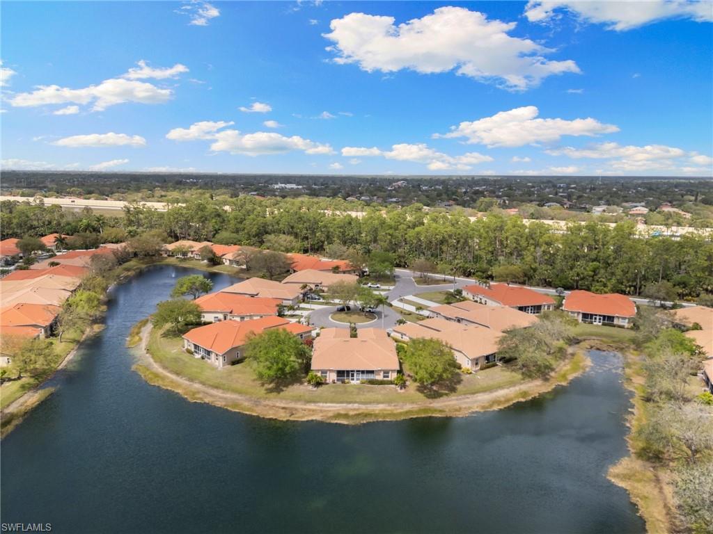 8140 Chancel Court, Unit 2 Naples, FL 34104 - Photo 35 of 39 Aerial view of residential area with a nearby body of water and a tree filled landscape