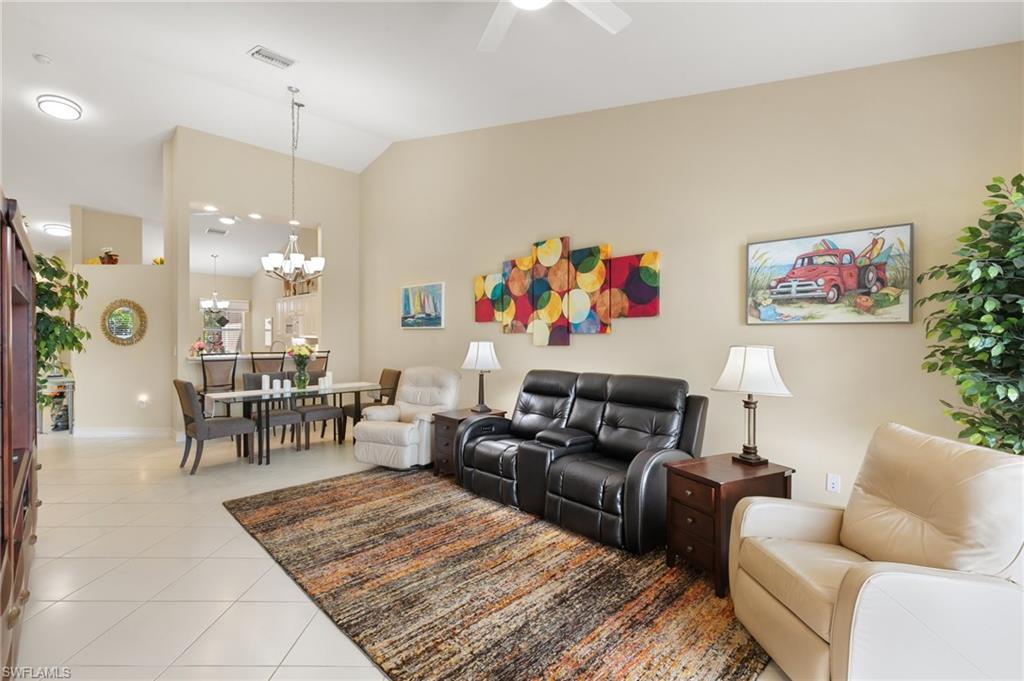 8140 Chancel Court, Unit 2 Naples, FL 34104 - Photo 5 of 39 Living area featuring light tile patterned flooring, lofted ceiling, hanging lights, and ceiling fan