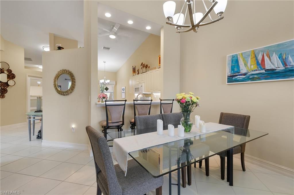 8140 Chancel Court, Unit 2 Naples, FL 34104 - Photo 10 of 39 Dining room with a chandelier, a ceiling fan, light tile patterned flooring, and lofted ceiling