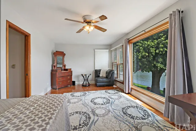 a bedroom with a bed chandelier and a window