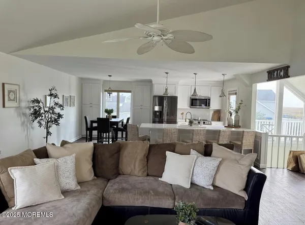 a living room with furniture kitchen view and a chandelier