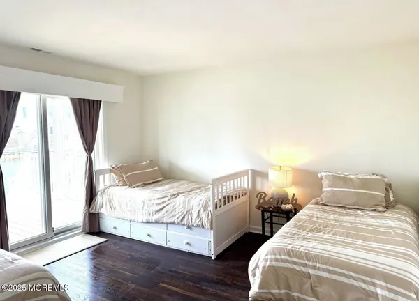a bedroom with two beds and wooden floor
