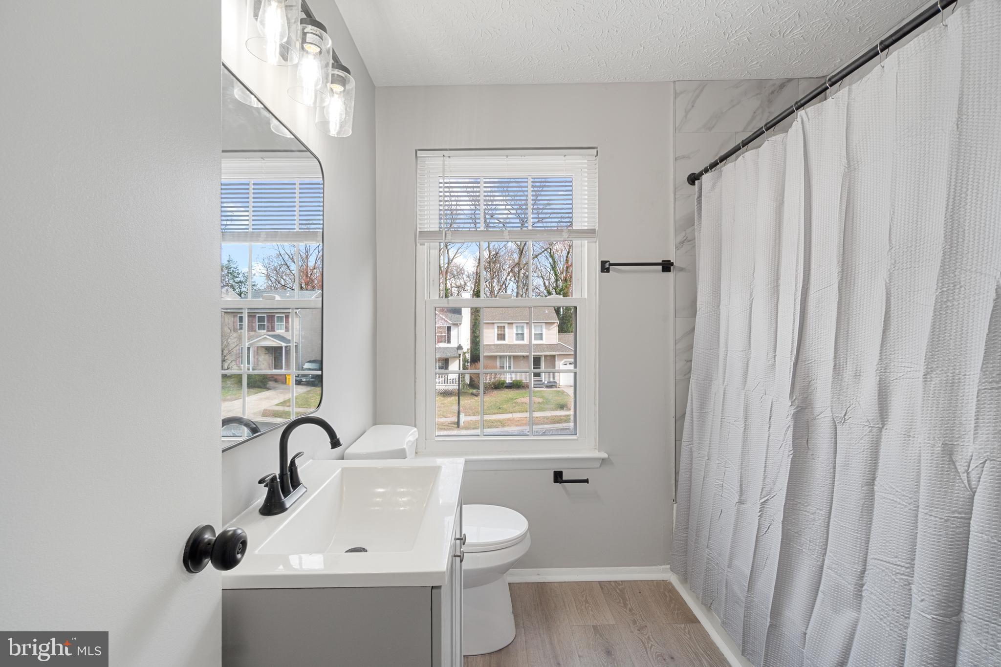8546 Skipjack Place Pasadena, MD 21122 - Photo 12 of 20 a bathroom with a sink a toilet and a window