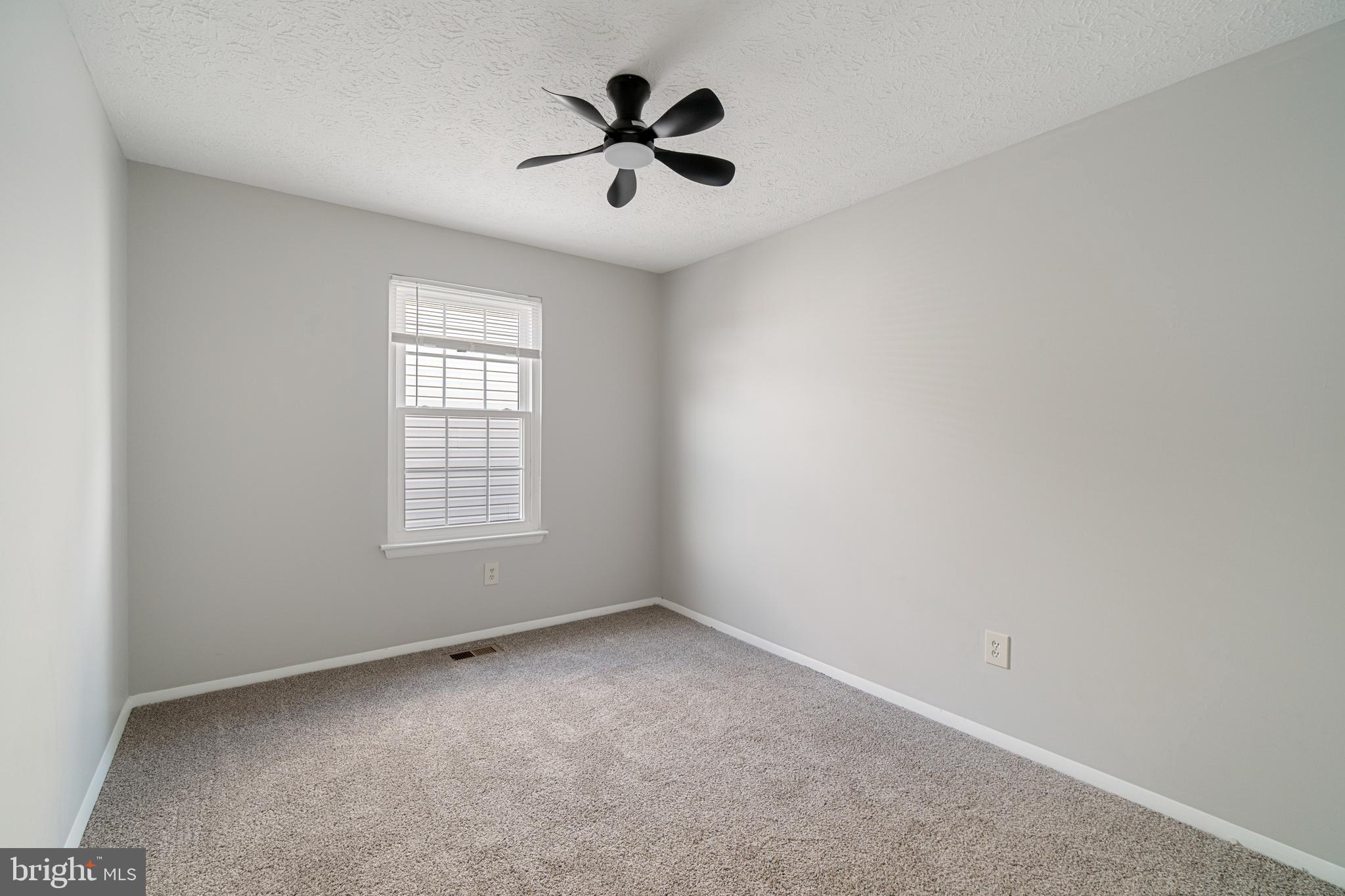 8546 Skipjack Place Pasadena, MD 21122 - Photo 10 of 20 an empty room with chandelier fan and windows