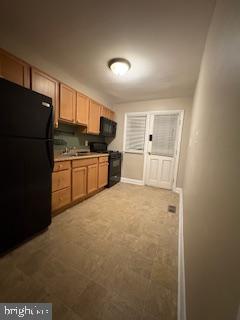 6166 Parkway Drive Baltimore, MD 21212 - Photo 5 of 9 a kitchen with a refrigerator and a sink