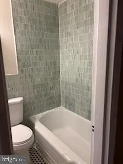 a white bath tub sitting next to a white toilet