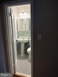 a bathroom with a sink a toilet and a mirror