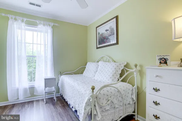 a bedroom with a bed and a painting on the wall