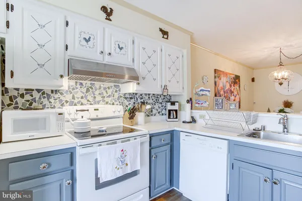 a kitchen with stainless steel appliances granite countertop white cabinets sink and stove