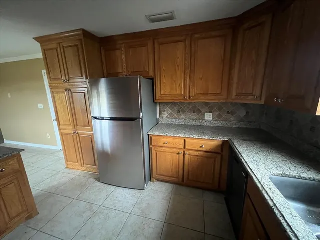 a kitchen with stainless steel appliances granite countertop a refrigerator a stove a sink and dishwasher