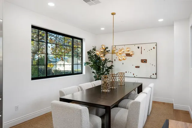 a view of a white house with a big yard and large trees